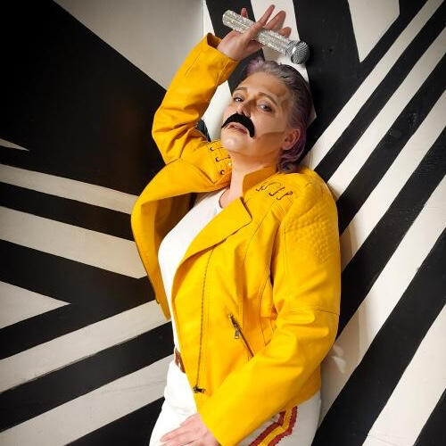 photo of Jasper Redwood in a yellow jacket against a black and white striped background