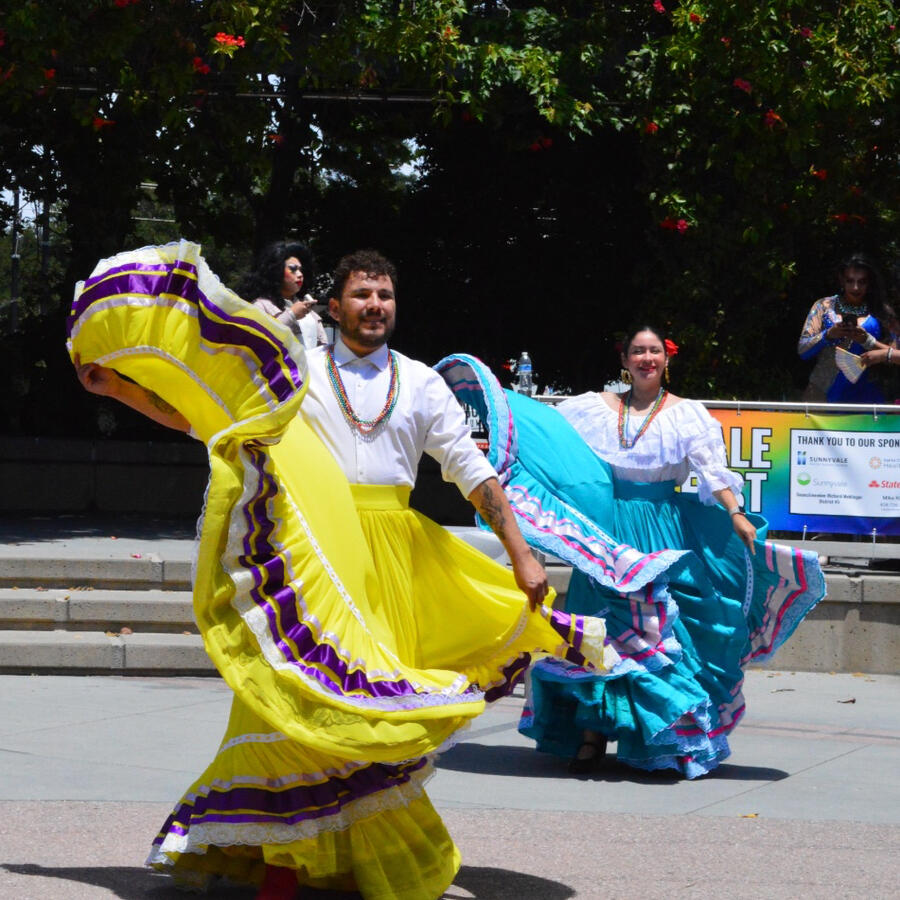 Folklorico dancers of multiple genders in traditional dresses